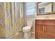 Bathroom with toilet, vanity with mirror, and shower featuring patterned curtain at 233 Creekstone Bnd, Peachtree City, GA 30269