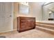 Bathroom vanity with dark wood cabinets, marble countertop, mirror, and bathtub with steps at 233 Creekstone Bnd, Peachtree City, GA 30269
