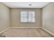 Empty bedroom featuring neutral walls, carpet, and a window allowing natural light at 233 Creekstone Bnd, Peachtree City, GA 30269