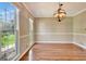 Bright dining room with hardwood floors, elegant chandelier, and large windows at 233 Creekstone Bnd, Peachtree City, GA 30269