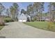 Beautiful home featuring a long driveway leading to a two-car garage, surrounded by lush greenery and mature trees at 233 Creekstone Bnd, Peachtree City, GA 30269