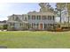 Traditional two-story home featuring a well-manicured lawn and mature landscaping around the facade at 233 Creekstone Bnd, Peachtree City, GA 30269
