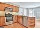 Well-lit kitchen with stainless steel appliances, wooden cabinets, and granite countertops for a modern, functional space at 233 Creekstone Bnd, Peachtree City, GA 30269