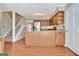 Open kitchen showcases stainless steel appliances, wood cabinetry, and seamless access to the staircase at 233 Creekstone Bnd, Peachtree City, GA 30269