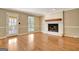 Bright living room featuring a white brick fireplace and hardwood floors at 233 Creekstone Bnd, Peachtree City, GA 30269