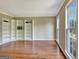 Bright living room featuring hardwood floors, built-in shelving and natural light from large windows at 233 Creekstone Bnd, Peachtree City, GA 30269