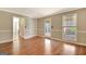 Spacious living room with hardwood floors, built-in shelving, and access to the porch at 233 Creekstone Bnd, Peachtree City, GA 30269