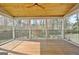 Large screened porch with wood floors, ceiling fan, and views of the backyard at 233 Creekstone Bnd, Peachtree City, GA 30269