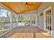 Covered porch with wood floors, ceiling fan, railing, and yard access at 233 Creekstone Bnd, Peachtree City, GA 30269