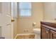 Bathroom with a toilet, vanity with wood cabinet, and a window with horizontal blinds at 233 Creekstone Bnd, Peachtree City, GA 30269