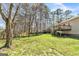 This backyard showcases a spacious lawn, mature trees, and a wooden deck at 104 Amberidge Nw Dr, Cartersville, GA 30121