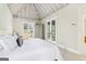 Bedroom with a cathedral ceiling, white walls and bedding, and french doors to a patio at 1009 Institute Nw St, Conyers, GA 30012
