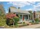 Charming home featuring a metal roof, inviting front porch, and vibrant landscaping with colorful azaleas at 1009 Institute Nw St, Conyers, GA 30012