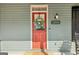 Close-up of a welcoming red front door with glass panel, adorned with a wreath and house number at 1009 Institute Nw St, Conyers, GA 30012