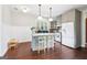 Bright and open kitchen featuring an island with seating, white appliances, and hardwood floors throughout at 1009 Institute Nw St, Conyers, GA 30012