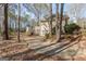Exterior of home with deck stairs and ground level entry surrounded by mature trees at 115 Flagstop Run, Fayetteville, GA 30215
