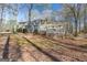 Expansive backyard showcasing a large deck perfect for entertaining, surrounded by mature trees and landscaping at 115 Flagstop Run, Fayetteville, GA 30215