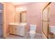 Well-lit bathroom featuring a vanity with storage, a toilet, and a shower with glass door at 115 Flagstop Run, Fayetteville, GA 30215
