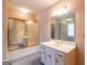 Bathroom features a vanity with a sink and mirror, plus a bathtub with sliding glass doors at 115 Flagstop Run, Fayetteville, GA 30215