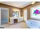 Primary bath showcasing a makeup vanity, stained glass window, and Jacuzzi tub at 115 Flagstop Run, Fayetteville, GA 30215