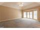 Spacious carpeted bedroom with a ceiling fan and French doors at 115 Flagstop Run, Fayetteville, GA 30215