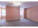 Spacious bedroom with neutral carpet, a ceiling fan, and natural light from two windows at 115 Flagstop Run, Fayetteville, GA 30215