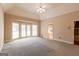 Large bedroom featuring neutral walls, ceiling fan, French doors and windows for ample natural light at 115 Flagstop Run, Fayetteville, GA 30215
