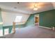 Bright bonus room featuring a skylight, staircase, and doorway to another room with built-in shelves at 115 Flagstop Run, Fayetteville, GA 30215