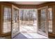 Deck view through open french doors showing natural wood decking, rails and natural surroundings at 115 Flagstop Run, Fayetteville, GA 30215