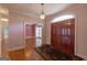 Elegant foyer with hardwood floors, a chandelier, and a view into a living room, creating a welcoming ambiance at 115 Flagstop Run, Fayetteville, GA 30215