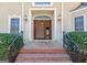 Inviting front entrance with a beautiful mahogany double door, brick steps and manicured shrubbery at 115 Flagstop Run, Fayetteville, GA 30215