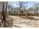 Set back home with a long driveway and manicured lawn, surrounded by mature trees at 115 Flagstop Run, Fayetteville, GA 30215
