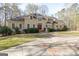 Charming front exterior featuring circular driveway, fountain, mature trees and impeccable landscaping at 115 Flagstop Run, Fayetteville, GA 30215