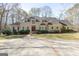 Stately home featuring a lush lawn, mature trees, and a circular driveway with a decorative fountain centerpiece at 115 Flagstop Run, Fayetteville, GA 30215
