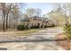 Large home featuring an expansive lawn, mature trees, and a long driveway with a fountain feature at 115 Flagstop Run, Fayetteville, GA 30215