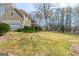 Well-manicured front yard featuring a lush lawn, mature trees, and charming curb appeal at 115 Flagstop Run, Fayetteville, GA 30215