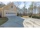 Attached two-car garage with a paved driveway and well-maintained landscaping, offering convenience and curb appeal at 115 Flagstop Run, Fayetteville, GA 30215