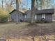 Wide shot of the backyard showing siding on the back of the home and wooded surrounding area at 191 Charles Cox Dr, Canton, GA 30115
