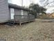 Rear exterior view featuring wood siding, a back door, and a small deck in the backyard at 191 Charles Cox Dr, Canton, GA 30115