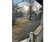 A glimpse of the front yard with sparse grass and mature trees, as seen from a weathered porch at 191 Charles Cox Dr, Canton, GA 30115