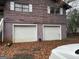 Rear exterior view featuring attached two car garage with white doors at 191 Charles Cox Dr, Canton, GA 30115