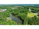 Aerial view overlooking a tranquil pond nestled between lush greenery and scattered surrounding buildings at 129 Old Norton Rd, Fayetteville, GA 30215