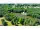 Aerial view of a home nestled next to a calm lake surrounded by trees in a lovely neighborhood at 129 Old Norton Rd, Fayetteville, GA 30215