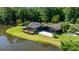Aerial view of a modern home on a lush lot with a pond, deck, and patio at 129 Old Norton Rd, Fayetteville, GA 30215
