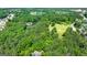 Aerial view showing the homes location amongst a lush canopy of trees and with winding road nearby at 129 Old Norton Rd, Fayetteville, GA 30215