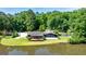 Waterfront home with a spacious deck, patio area, and manicured lawn, offering serene lakeside living at 129 Old Norton Rd, Fayetteville, GA 30215