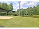 Lawn stretches to the lake behind a dark gray home with lush green landscaping at 129 Old Norton Rd, Fayetteville, GA 30215