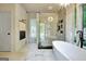 Bright bathroom featuring a freestanding tub, glass shower, and designer light fixtures and neutral color palette at 129 Old Norton Rd, Fayetteville, GA 30215