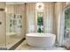 Bathroom showing walk-in shower and soaking tub with view of wooded area at 129 Old Norton Rd, Fayetteville, GA 30215