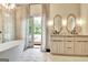 Bright, luxurious bathroom featuring soaking tub, backyard views, and double vanity at 129 Old Norton Rd, Fayetteville, GA 30215